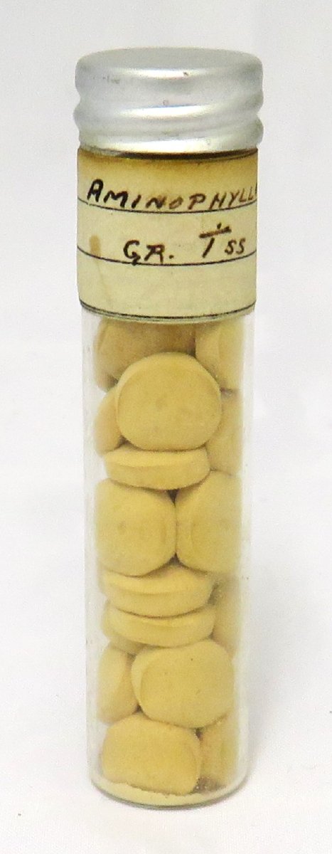Clear medicine vial with metal screw cap and handwritten label "Aminophylline".