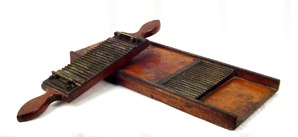 Wooden pill cutter with brass pieces. Brass is scalloped to create pill tubes which are pressed and cut. The handle pieces fits over the base to do this and has the same scallops.